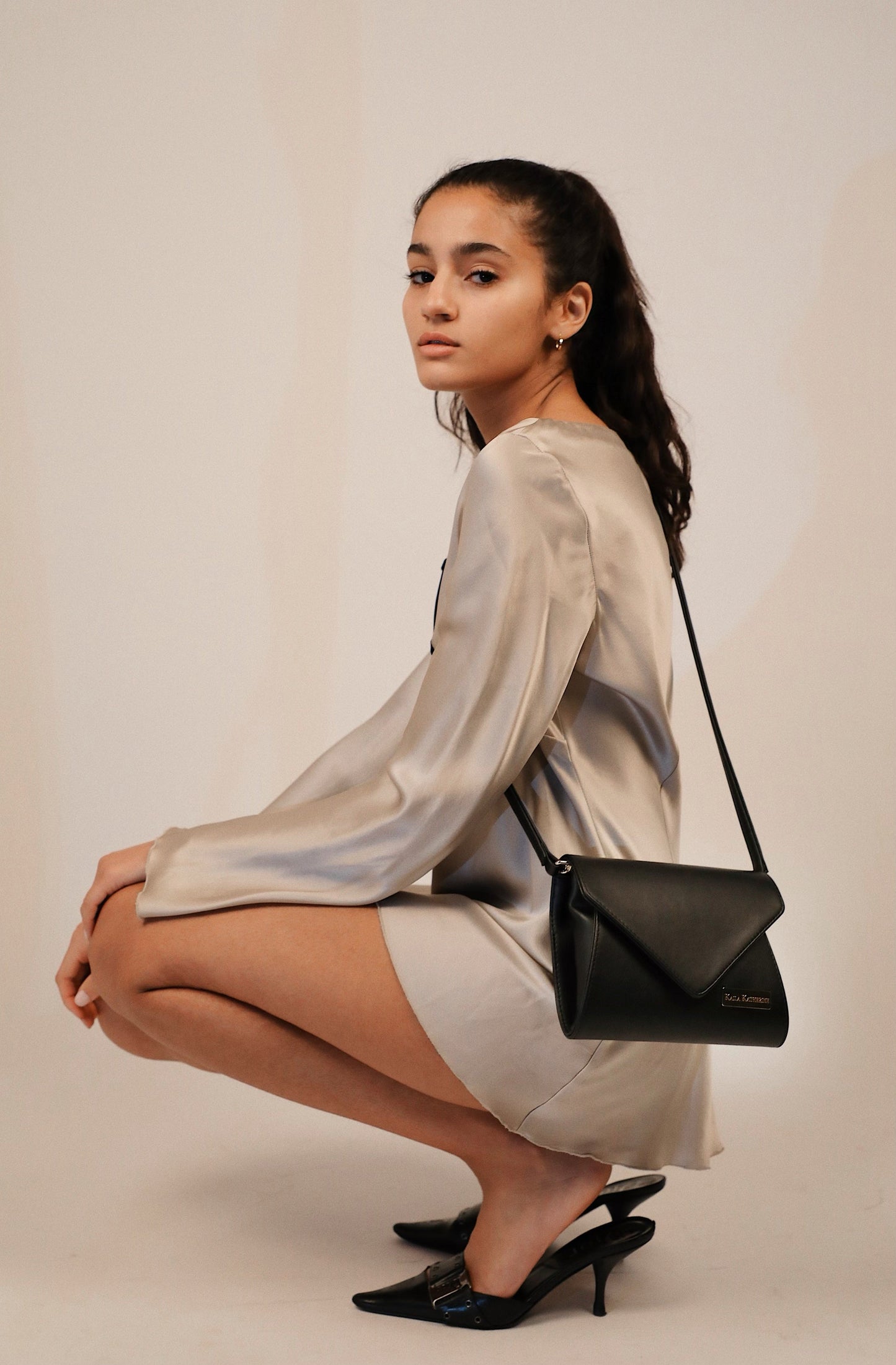 dark hear girl wearing black kaila katherine vegan leather brixton clutch shoulderbag